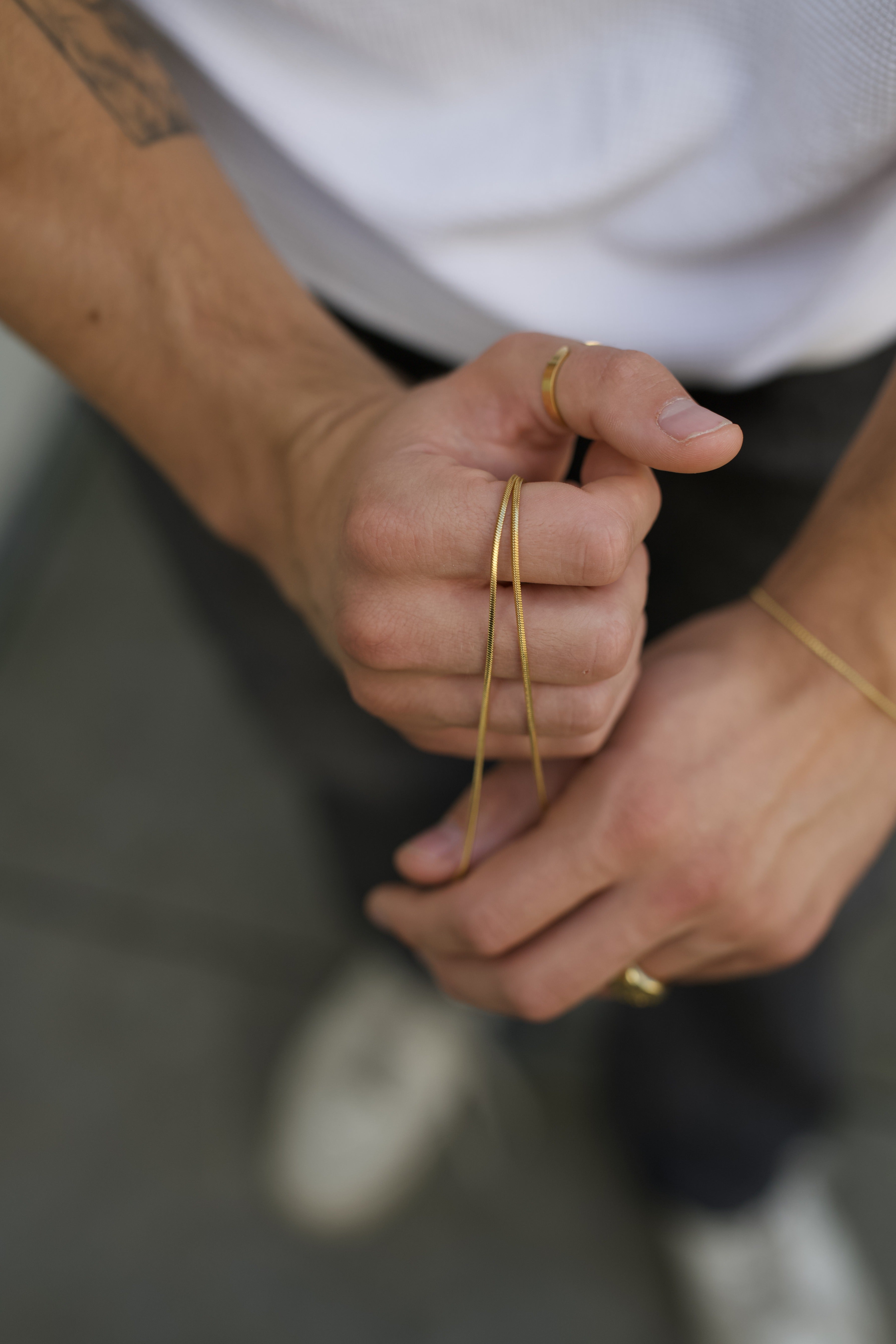 gold chain on hand with gold ring and gold bracelet