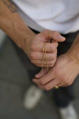 gold chain on hand with gold ring and gold bracelet