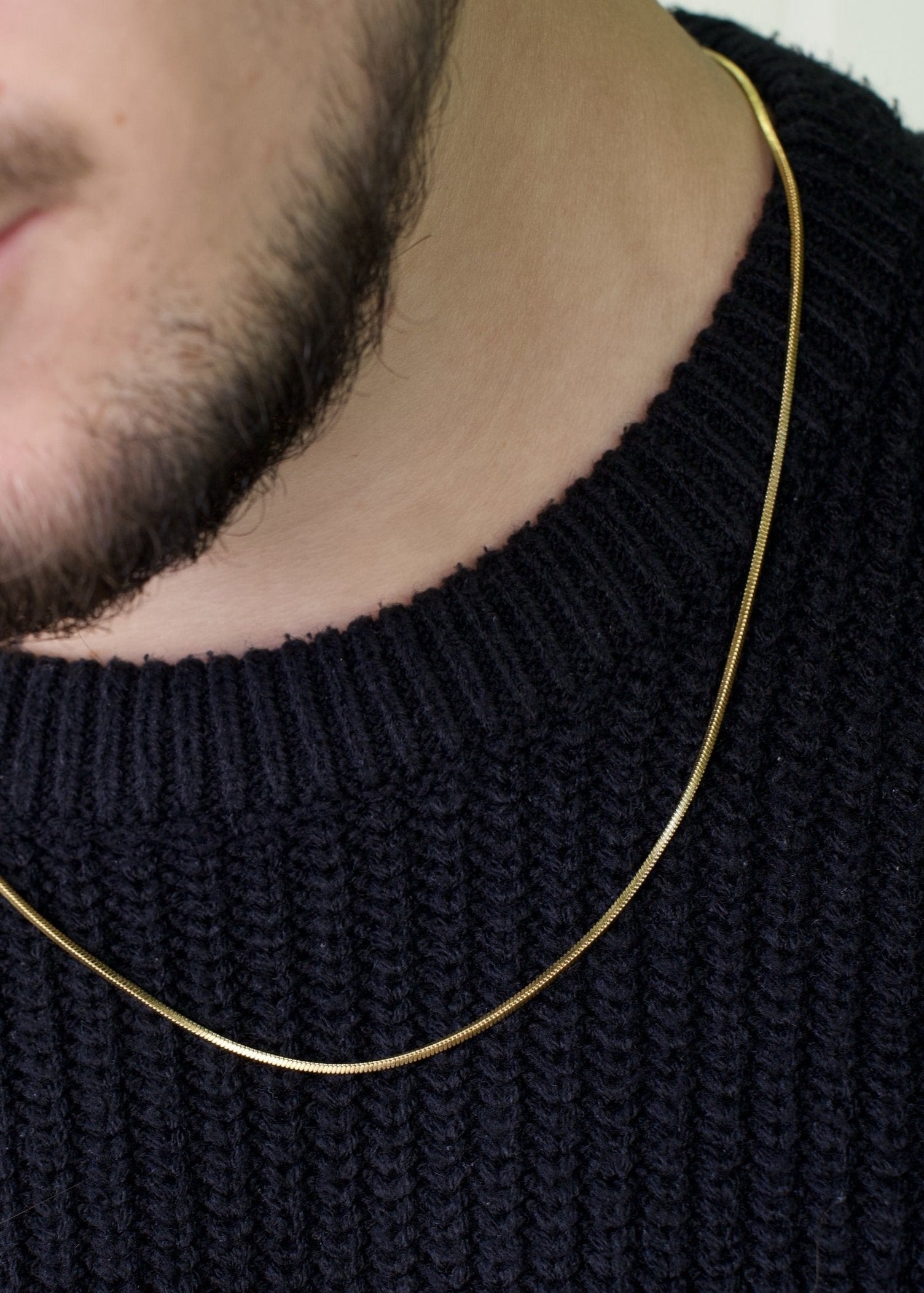 man wearing gold stainless steel chain
