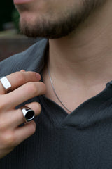 man wearing silver chain and silver rings