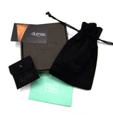 Dumas cleaning kit with black pouch, green cloth, and black drawstring bag on a white background