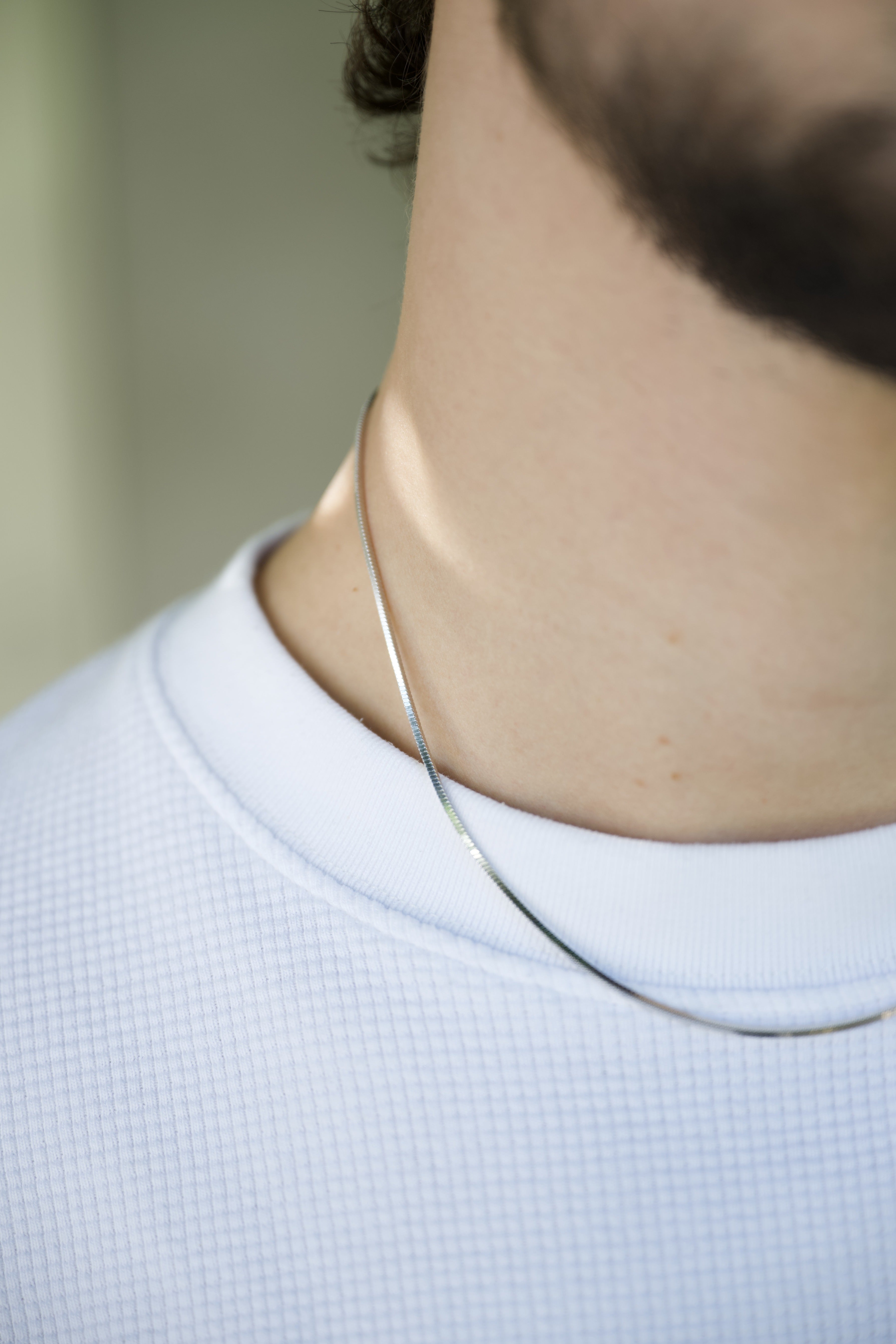 man wearing silver chain close-up