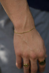 gold link bracelet on wrist man